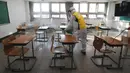 Petugas kesehatan mendisinfeksi ruang kelas untuk ujian masuk perguruan tinggi di Seoul, Korea Selatan, Selasa (1/12/2020). Sekitar 490.000 siswa lulusan sekolah menengah atas di Korea Selatan akan menjalani Tes Kemampuan Skolastik Perguruan Tinggi pada 3 Desember 2020. (AP Photo/Ahn Young-joon)