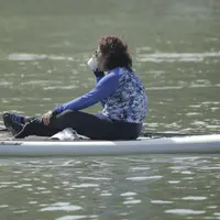 Menteri Kelautan dan Perikanan, Susi Pudjiastuti, minum kopi saat bermain paddle board di Danau Sunter, Jakarta, Minggu (25/2/2018). Kegiatan ini dilakukan dalam rangka Festival Danau Sunter. (Bola.com/Okie Prabhowo)
