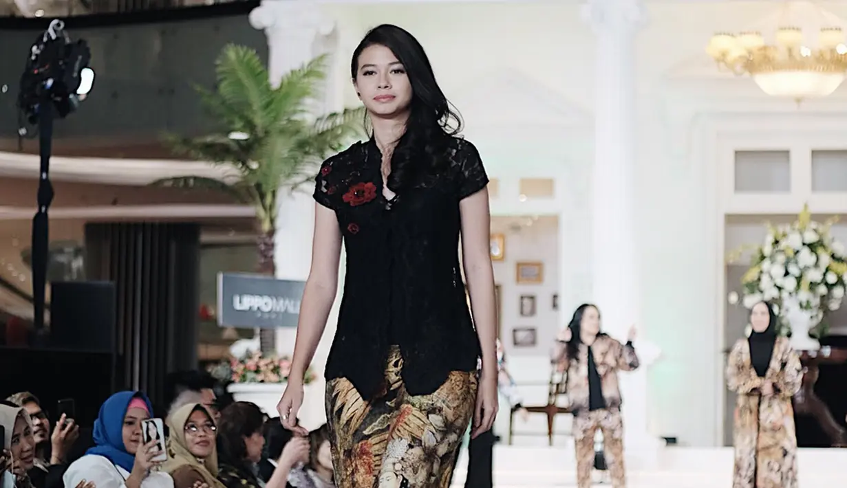 Penampilan Yuki saat berjalan di atas panggung catwalk mengenakan kebaya kutu baru hitam dengan kombinasi celana bermotif. (Liputan6.com/IG/@yukikt)