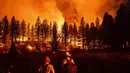 Petugas pemadam kebakaran memantau kobaran api di Kompleks Beckwourth, yang membakar di Hutan Nasional Plumas, California (8/7/2021). Periode antara 1 Januari hingga 4 Juli 2021 sudah terjadi sebanyak 4.599 kebakaran yang menghanguskan hutan seluas 297 kilometer persegi. (AP Photo/Noah Berger)