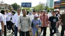 Mantan Wakil Presiden Jusuf Kalla atau JK (kiri) didampingi istrinya Mufidah berjalan kaki saat tiba di kampung halamannya, Makassar, Sulawesi Selatan, Sabtu (26/10/2019). JK disambut meriah warga Makassar. (Liputan6.com/HO/Tim JK)