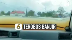 Seorang pengendara mobil lakukan aksi nekat dengan terobos banjir yang hampir menutupi mobilnya. Alhasil, air banjir pun masuk ke dalam mobilnya.
