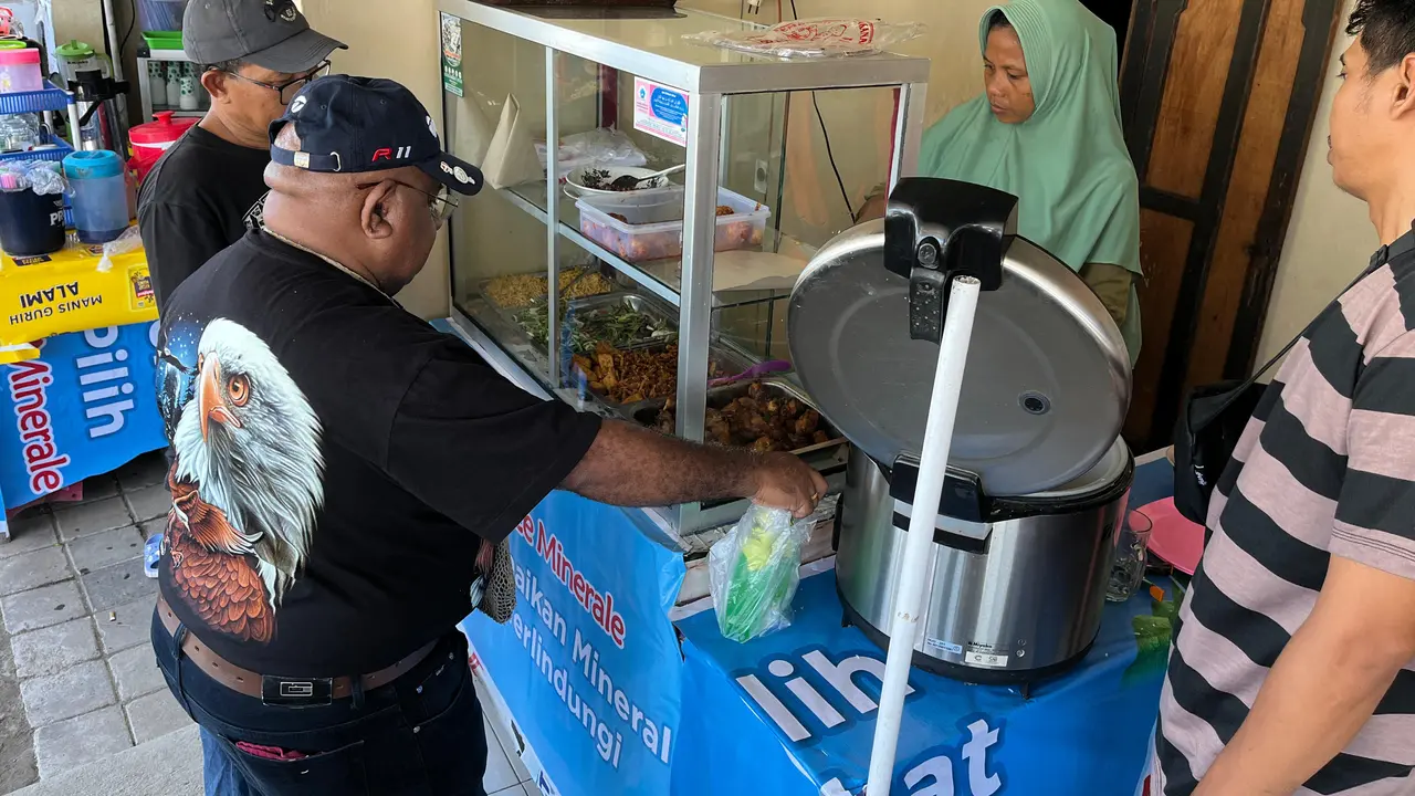 Ibu Rizal Pemilik Rumah Makan sedang melayani pelanggan makan di tempat di sebrang Pertamina mandalika Sirkuit.
