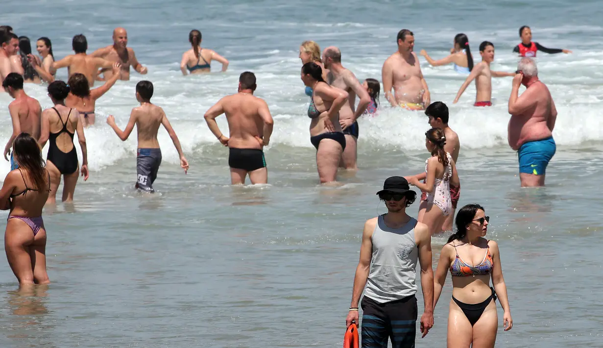 Orang-orang menikmati laut di Biarritz barat daya Prancis, Rabu (18/5/2022). Cuaca panas diperkirakan akan berlangsung selama beberapa hari di seluruh Prancis. (AP Photo/Bob Edme)