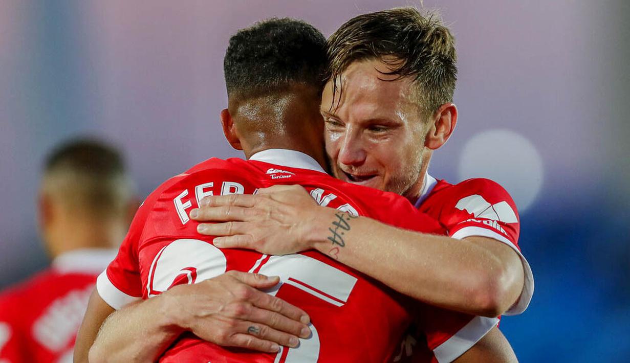 Pemain Sevilla, Fernando, dipeluk oleh Ivan Rakitic, usai mencetak gol ke gawang Real Madrid pada laga Liga Spanyol di Stadion Alfredo di Stefano, Minggu (10/5/2021). Kedua tim bermain imbang 2-2. (AP/Manu Fernandez)