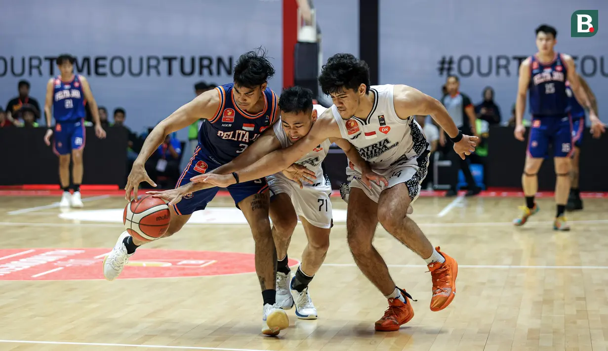 Pemain Satria Muda, Widyanta Putra Teja (tengah) dan Julian Alexandre Chalias (kanan) berusaha merebut bola dari pemain Pelita Jaya, Yesaya Alessandro Saudale pada laga gim ketiga final IBL All Indonesia 2024 yang berlangsung di Hall Basket, Senayan, Jakarta, Sabtu (06/10/2024). Pelita Jaya menang dengan skor 75-70. (Bola.com/Bagaskara Lazuardi)
