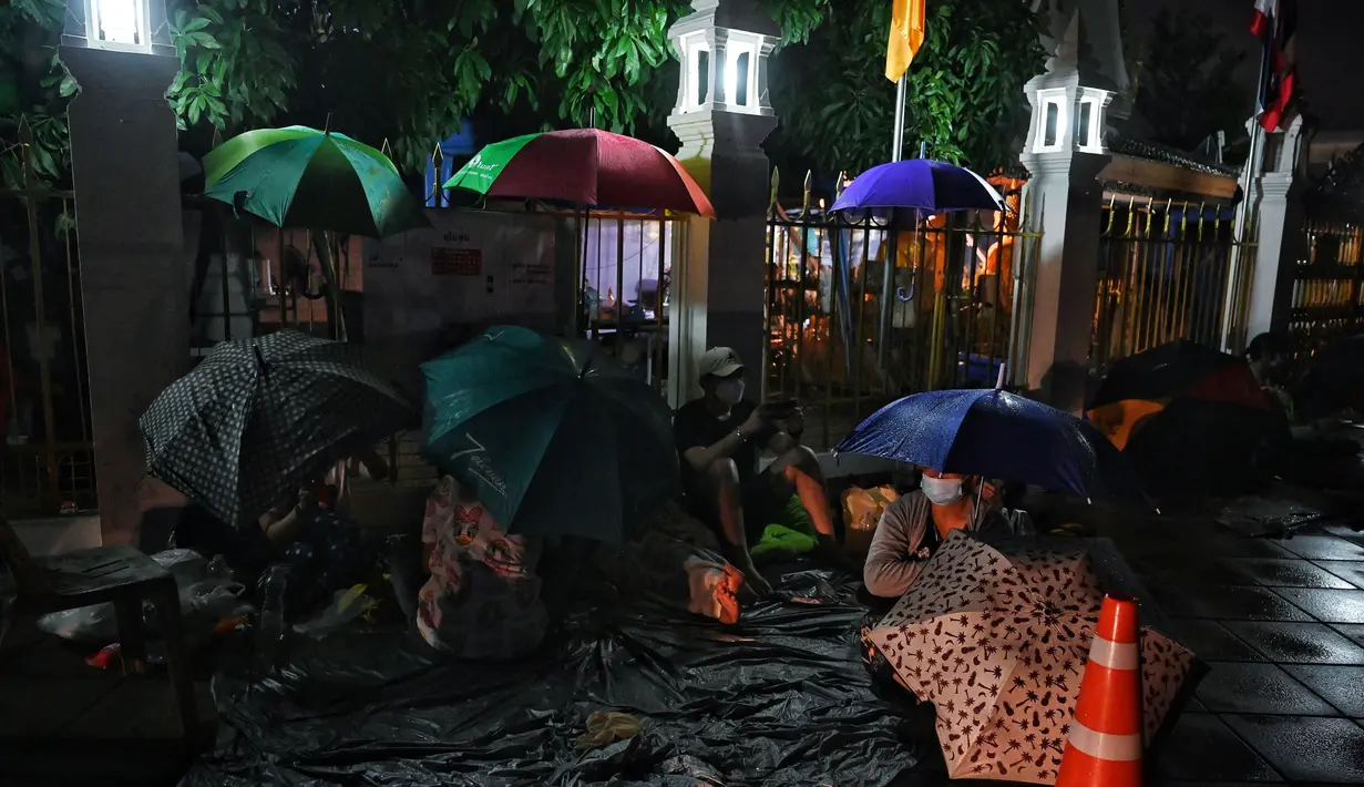 Warga tidur saat antre semalaman untuk tes swab Covid-19 gratis di Wat Phra Sri Mahathat Woramahawihan di Bangkok, Jumat (9/7/2021) dinihari. Thailand pada Kamis (8/7/2021), mencatat rekor 75 kematian Covid-19 dalam 24 jam terakhir, sehingga jumlah kematian menjadi 2.462. (Lillian SUWANRUMPHA/AFP)