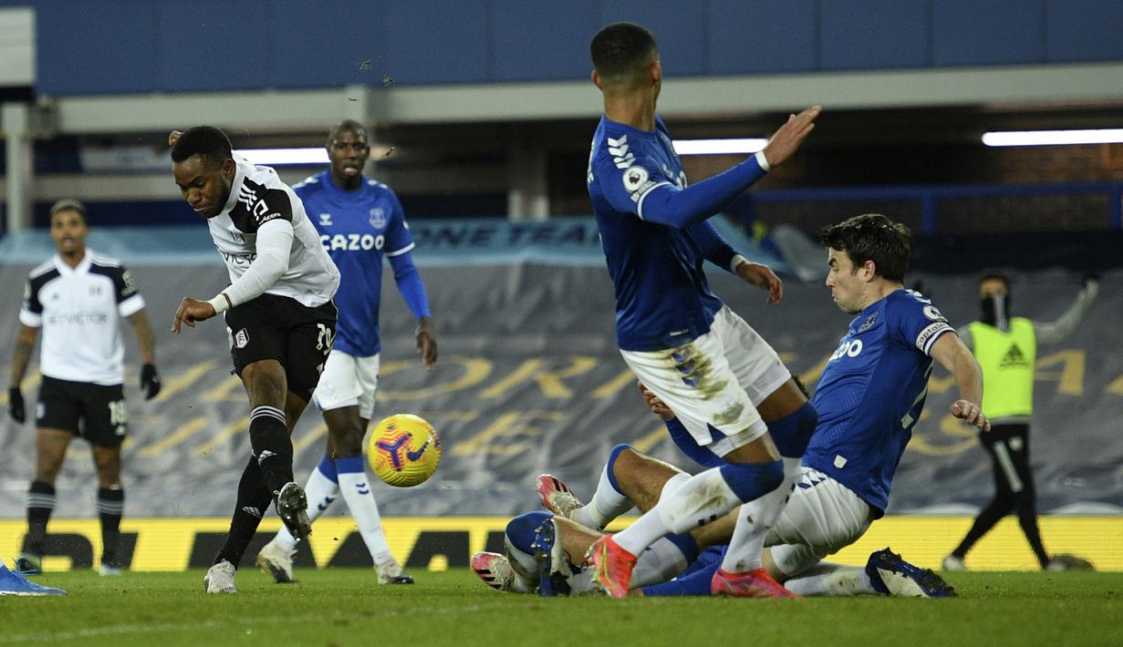 Gelandang Fulham, Ademola Lookman (kiri) melepaskan tendangan yang berusaha dibendung bek Everton dalam laga lanjutan Liga Inggris 2020/21 pekan ke-24 di Goodison Park, Liverpool, Minggu (14/2/2021). Fulham menang 2-0 atas Everton. (AP/Oli Scarff/Pool)