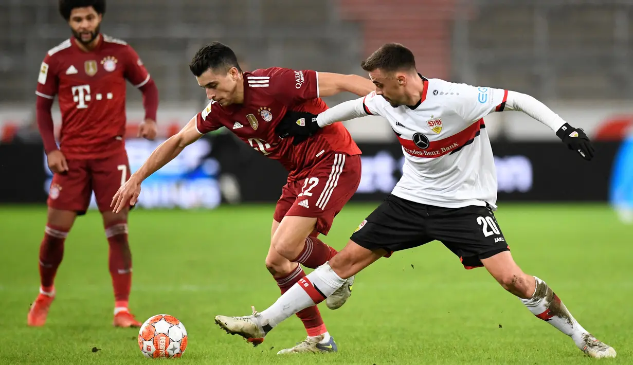 Gelandang Bayern Munchen Marc Roca (tengah) berebut bola dengan gelandang VfB Stuttgart Philipp Foerster pada lanjutan Liga Jerman di Mercedes-Benz Arena, Rabu (15/12/2021) dinihari WIB. Bayern Munchen sukses melumat VfB Stuttgart dengan skor 5-0. (Thomas KIENZLE/AFP)