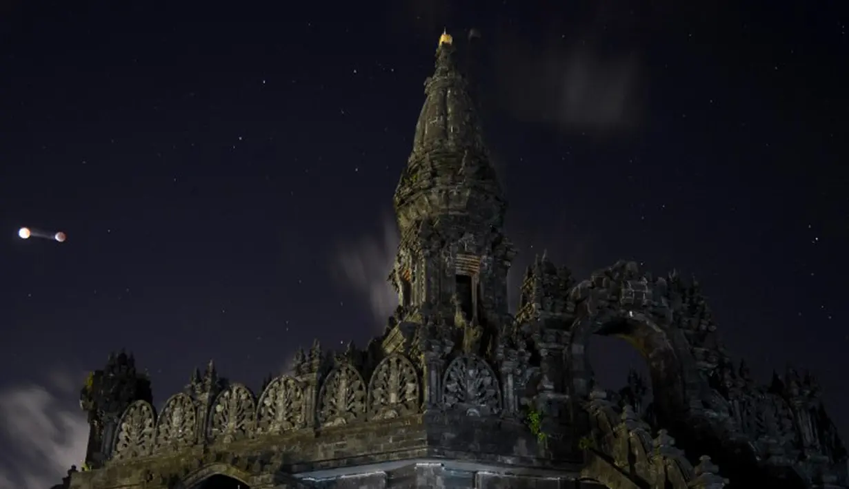 Gerhana bulan parsial mulai terlihat di sebelah monumen di Jimbaran, Bali, Indonesia, Sabtu Sabtu (4/4/2015). (AFP PHOTO/Sonny TUMBELAKA)