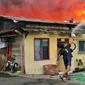 Warga berusaha memadamkan api saat terjadi kebakaran di kawasan padat penduduk di Jalan Simprug Golf II RT 4/8, Grogol Selatan, Kebayoran Lama, Jakarta Selatan, Minggu (21/8/2022). Belum diketahui penyebab kebakaran yang membakar puluhan rumah tersebut. (Liputan6.com/Angga Yuniar)
