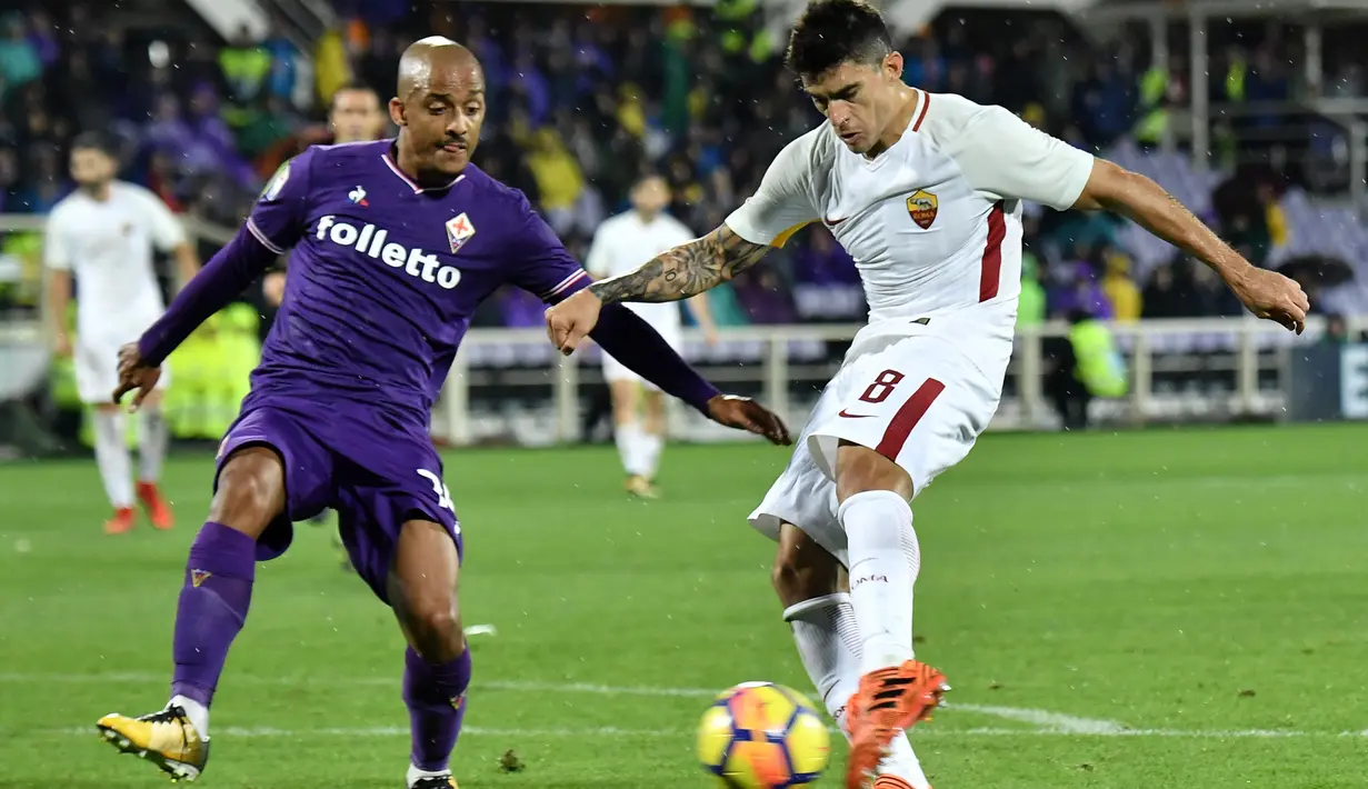 Pemain AS Roma, Diego Perotti (kanan) melepaskan tembakan saat diadang pemain Fiorentina pada laga Serie A di Artemio Franchi stadium, Florence, (5/11/2017). AS Roma menang 4-2. (AFP/Tiziana Fabi)