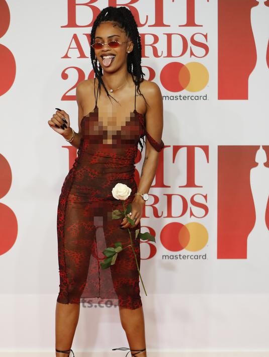 Gaya Diana De Brito, yang dikenal sebagai IAMDDB berpose di karpet merah saat tiba menghadiri BRIT Awards 2018 di London, Inggris (21/2). (AFP Photo/Tolga Akmen)