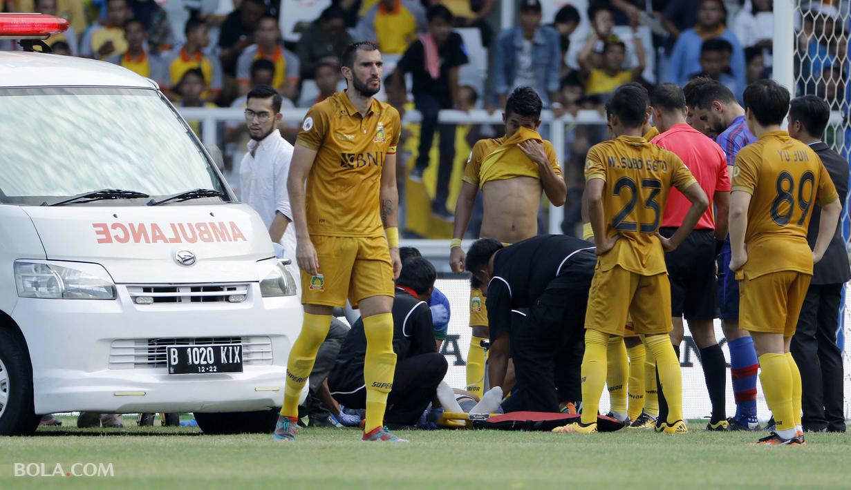 Awan Seto kiper Bhayangkara FC dievakuasi setelah insiden tabrakan dengan pemain FC Tokyo dalam laga persahabatan yang digelar di Stadion Utama Gelora Bung Karno, Senayan, Jakarta pada Sabtu (27/1/2018).  (Bola.com/Peksi Cahyo)