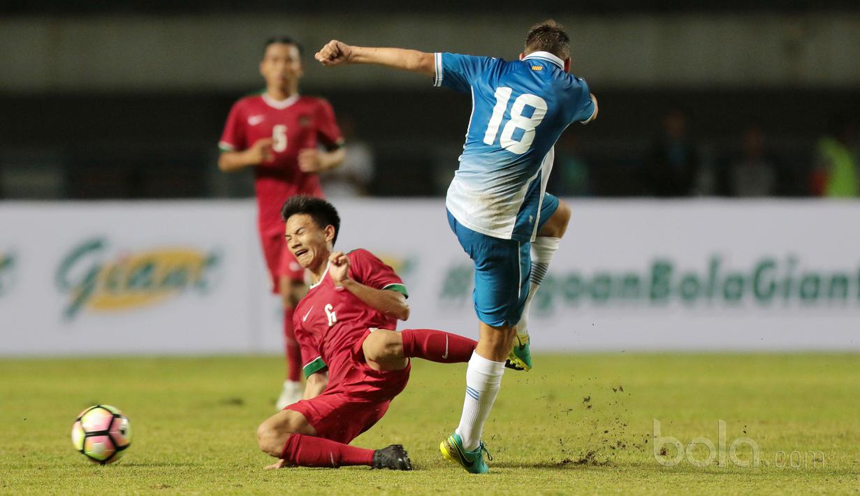 Pemain Timnas Indonesia U-19, Muhammad Iqbal (kiri) menahan laju bola sepakan pemain Espanyol B, Aitor Granados pada laga persahabatan di Stadion GBLA, Bandung, (15/7/2017). Timnas U-19 kalah 2-4. (Bola.com/Nicklas Hanoatubun)