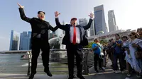 Kim Jong-un KW bernama Howard X dan Donald Trump KW, Dennis Alan berpose sambil melompat bersama di Merlion Park, Singapura (8/6). Dua orang yang mirip pemimpin negara Korut dan AS ini menghebohkan warga dan pengunjung. (AP/Wong Maye-E)