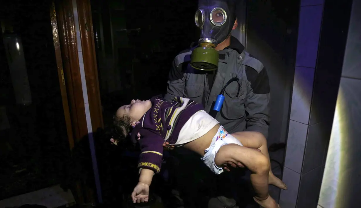 Penyelamat membawa seorang anak menyusul dugaan serangan senjata kimia di Kota Douma, dekat Damaskus, Suriah, Minggu (8/4). Petugas medis mengatakan serangan gas beracun di Douma telah menewaskan 70 orang. (Syrian Civil Defense White Helmets via AP)
