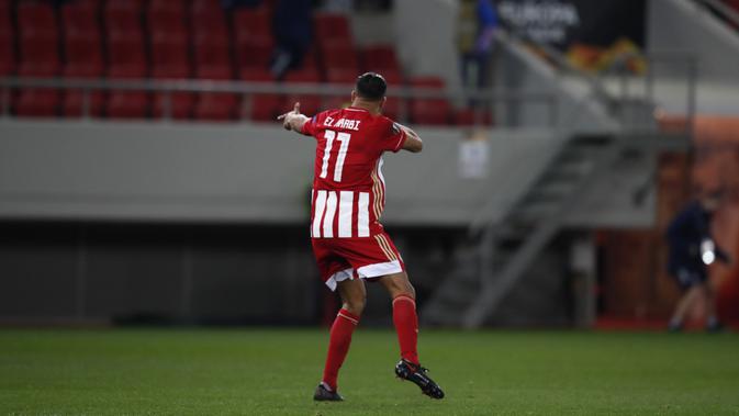 Penyerang Olympiakos,Youssef El-Arabi berselebrasi usai mencetak gol ke gawang Arsenal pada pada leg pertama babak 16 besar Liga Europa di stadion Georgios Karaiskakis, Athena, Jumat (12/3/2021). Tiga gol di markas Olympiakos menjadi modal penting Arsenal untuk laga selanjutnya. (AP Photo/Thanassis