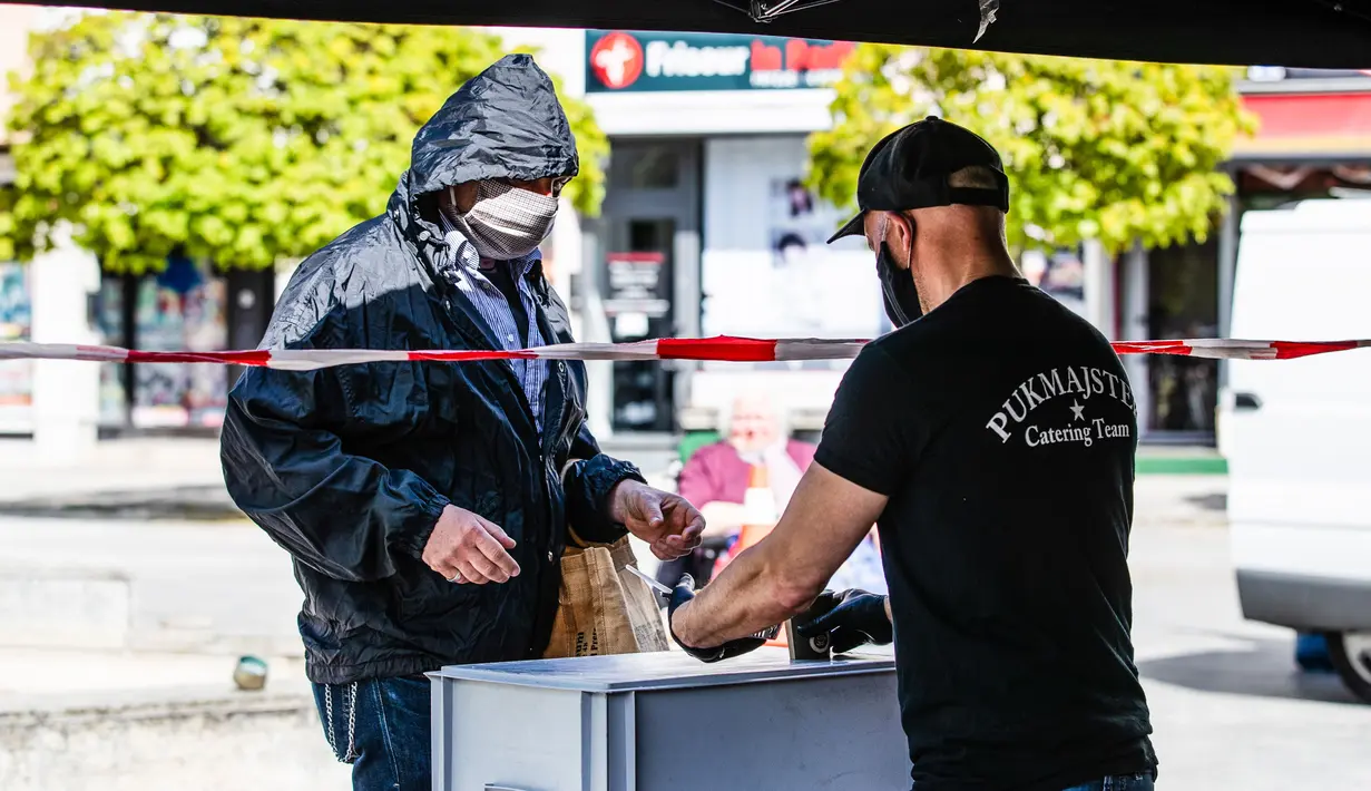 Staf perusahaan katering memberikan makanan gratis kepada pria di Berlin, Jerman (16/4/2020). Tingkat infeksi baru COVID-19 di Jerman terus berada di bawah masa puncak saat jumlah kasus terkonfirmasi bertambah 2.866 dalam satu hari menjadi 130.450. (Xinhua/Binh Truong)
