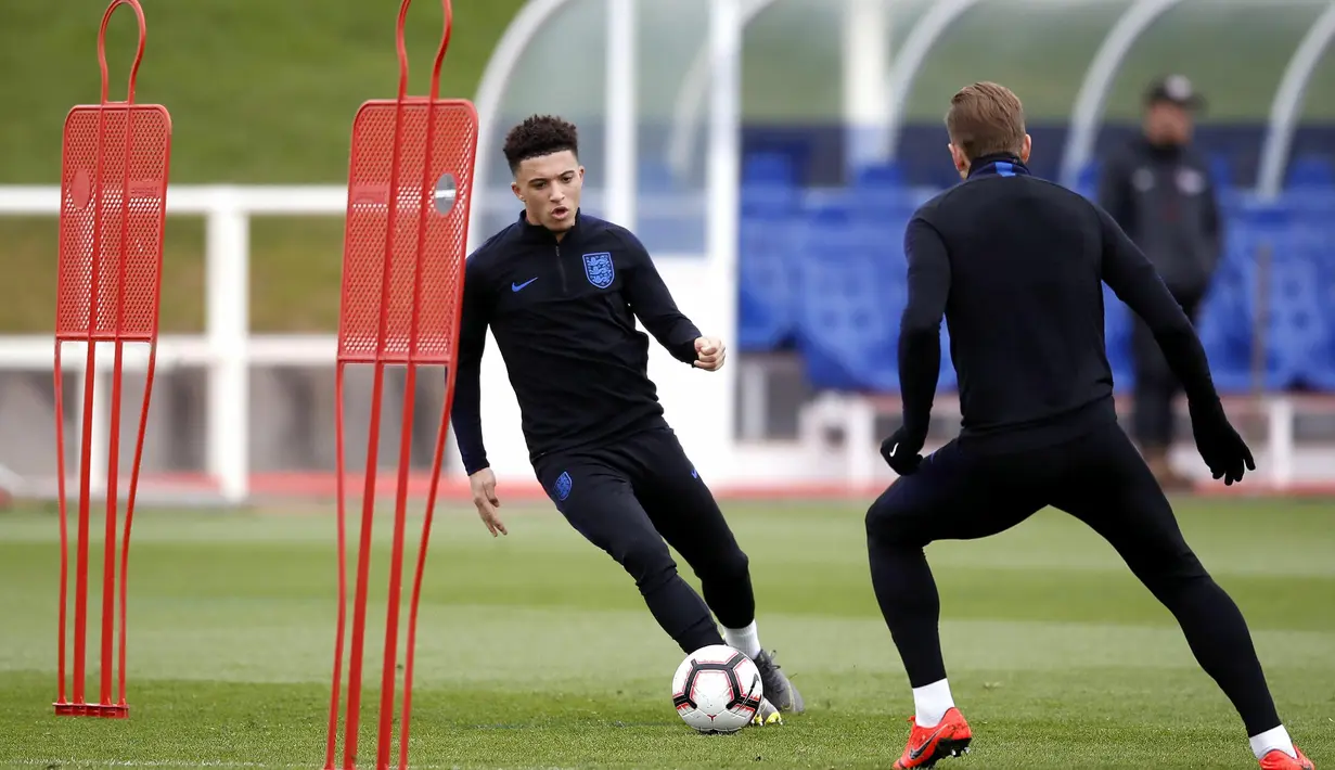 Pemain Inggris, Jadon Sancho, menggiring bola saat latihan jelang laga kualifikasi Piala Eropa di St George's Park, Selasa (19/3). Inggris akan berhadapan dengan Republik Ceko. (AP/Martin Rickett)