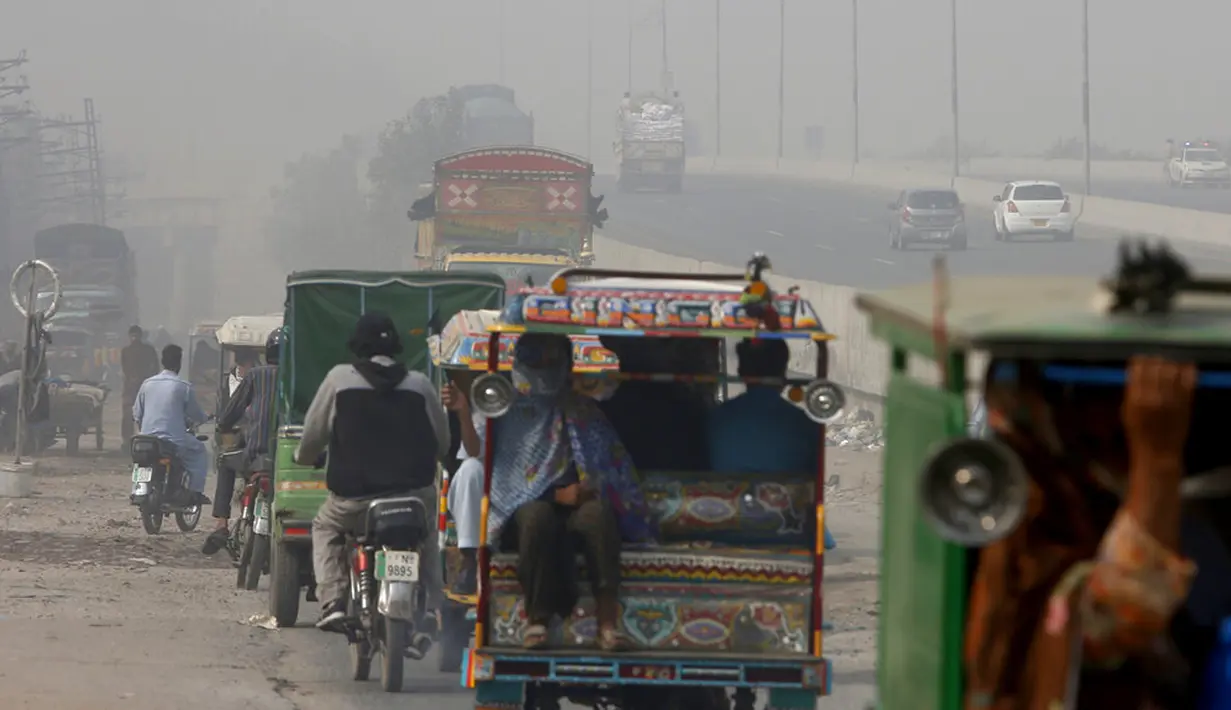 Orang-orang melakukan perjalanan saat kabut asap menyelimuti daerah Lahore, Pakistan, Rabu (11/11/2020). Kabut asap yang menyelimuti Lahore mendorong para dokter untuk mendesak orang-orang agar tetap di rumah. (AP Photo/K.M. Chaudary)