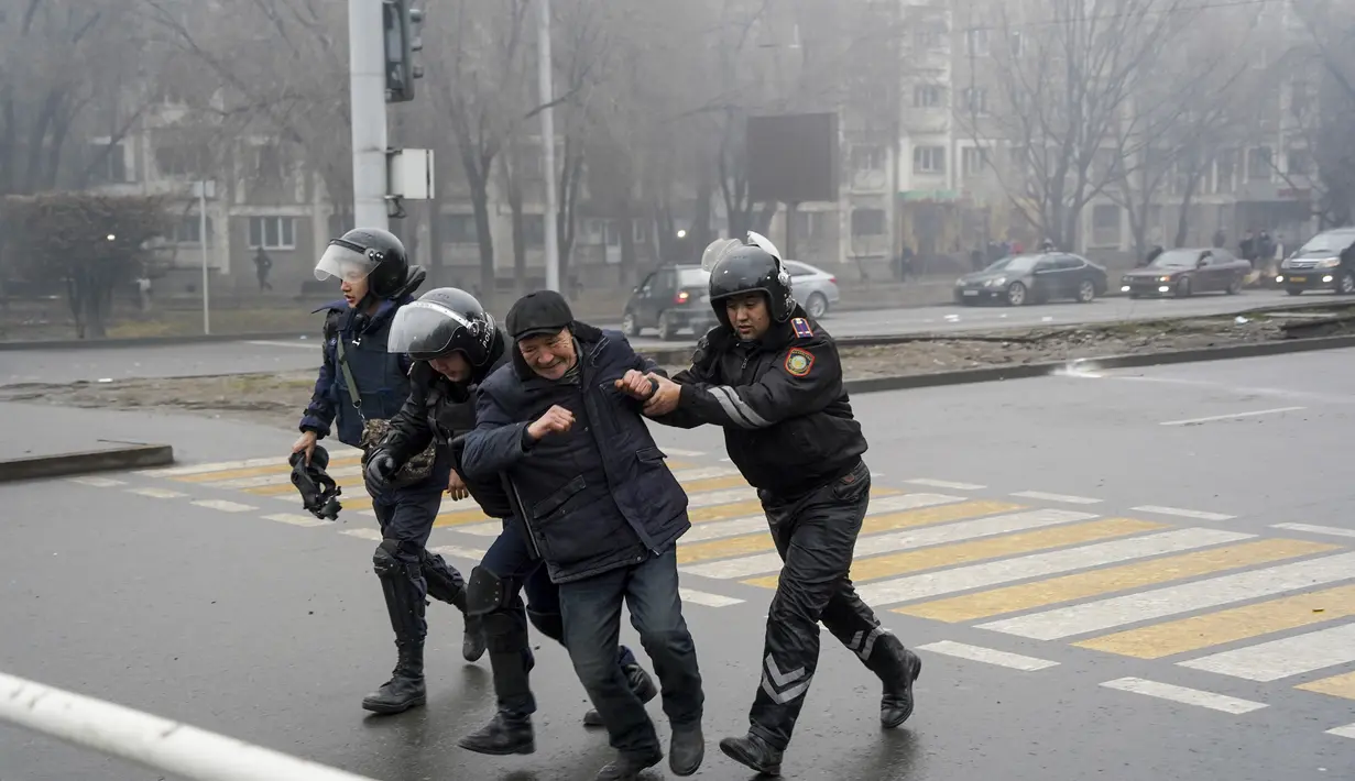 Petugas polisi menahan seorang demonstran selama protes di Almaty, Kazakhstan, Rabu (5/2/2022). Demonstran yang menolak kenaikan harga gas cair bentrok dengan polisi di kota terbesar Kazakhstan dan mengadakan protes di sekitar kota. (AP Photo/Vladimir Tretyakov)