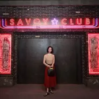 NI Ni mengenakan Gucci Ouverture 10 crew neck quartz tulle berwarna pink. Atasa lengan panjang ini dipadukan dengan rok midi plonge merah dengan detail plisse dan sabuk kulit hitam khas Gucci. (Foto: Gucci)