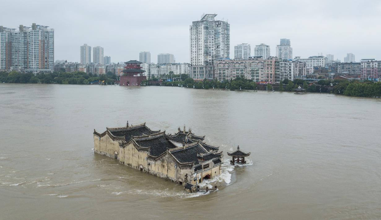 Foto pada 19 Juli 2020 menunjukkan kuil Guanyinge berumur 700 tahun yang dibangun di atas batu, terendam banjir akibat meluapnya sungai Yangtze di Wuhan, provinsi Hubei. Hujan lebat sejak bulan Juni telah menyebabkan sedikitnya 141 orang tewas dan memaksa hampir 15 juta orang dievakuasi. (STR/AFP)