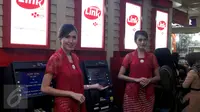 Dua model berdiri di depan mesin ATM Himbara Link saat peluncuran di pasar Tanah Abang, Jakarta, Senin (21/12). Bank-bank BUMN yang tergabung dalam Himbara adalah BRI, MANDIRI, BTN dan BNI. (Liputan6.com/Johan Tallo) 