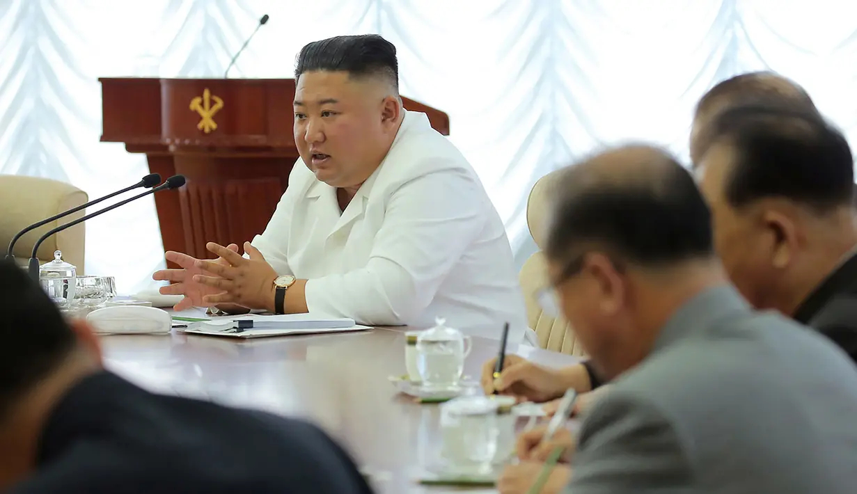 Pemimpin Korea Utara, Kim Jong-un berbicara selama pertemuan politbiro ke-13 dari Partai Buruh di lokasi yang dirahasiakan dalam gambar yang dirilis Senin (8/6/2020). Dalam pertemuan itu, Kim Jong-un juga membahas proyek-proyek ekonomi termasuk industri kimia. (Photo by STR / KCNA VIA KNS / AFP)