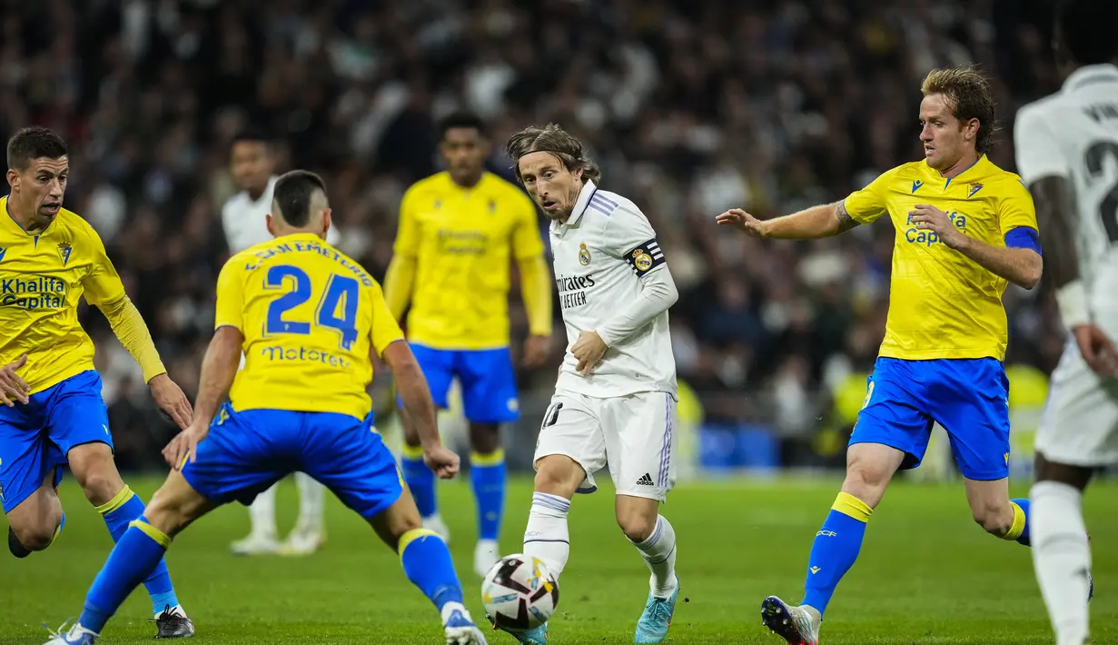 Gelandang Real Madrid Luka Modric (tengah) mengumpan bola saat bertanding melawan Cadiz selama pertandingan lanjutan La Liga Spanyol di stadion Santiago Bernabeu di Madrid, Jumat (11/11/2022). Madrid kini mengoleksi 35 poin dari 14 pertandingan, berjarark dua angka dari rival abadinya Barcelona. (AP Photo/Manu Fernandez)