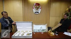 Petugas menunjukan tiga barang yang diduga termasuk dalam gratifikasi di Gedung KPK, Jakarta, Jumat (28/10). Barang tersebut diberikan perusahaan minyak asal Rusia untuk Presiden Jokowi seusai kunjungan kerjanya. (Liputan6.com/Helmi Affandi)