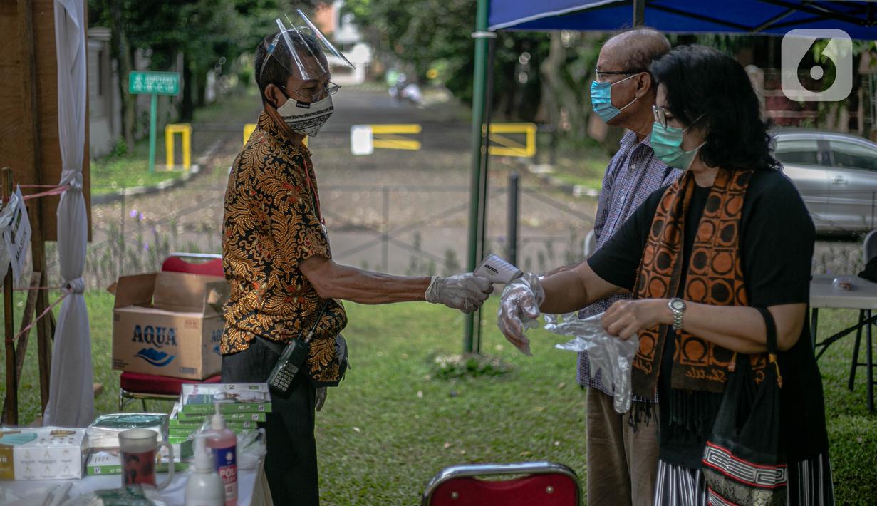 Petugas mengukur suhu warga sebelum memasuki TPS 69 Pisangan, Ciputat, Tangerang Selatan, Rabu (9/12/2020). pemungutan suara tersebut dengan menerapkan protokol kesehatan tersebut bertujuan untuk menghindari penularan COVID-19 pada pelaksanaan Pilkada 2020, serta menciptakan pemilu yang aman dan seh