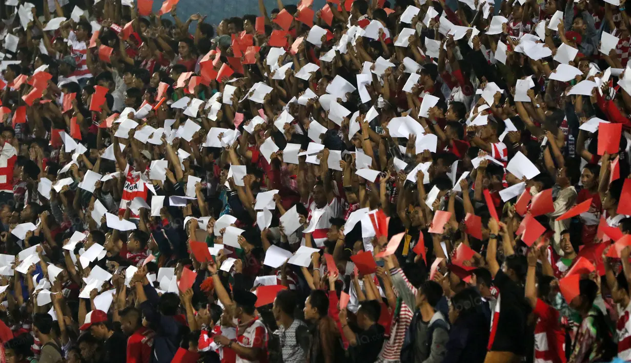 Aksi Suporter Madura United mendukung timnya melawan Persiba Balikpapan pada Torabika SC 2016 di Stadion Gelora Bangkalan, Senin(13/6/2016).  (Bola.com/Nicklas Hanoatubun)