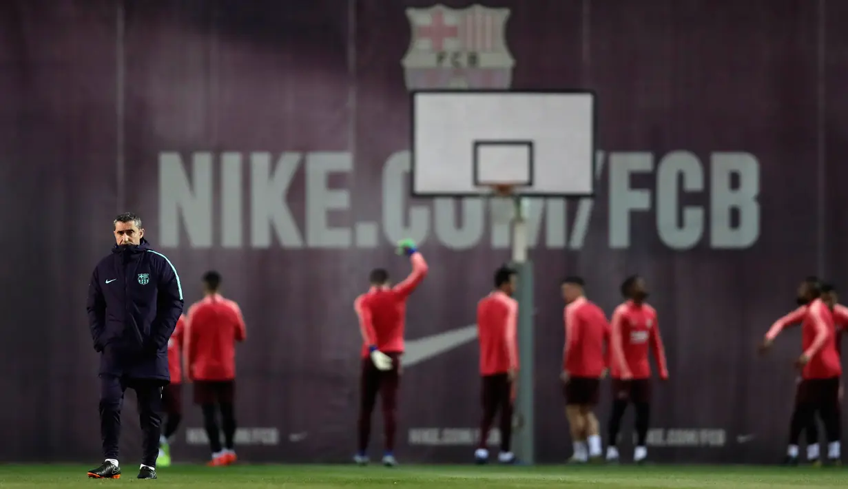 Pelatih Barcelona, Ernesto Valverde melihat para pemainnya berlatih jelang menghadapi wakil Prancis, Lyon pada leg kedua babak 16 besar Liga Champions di Sports Center FC Barcelona Joan Gamper, Spanyol (12/3). (AP Photo/Manu Fernandez)