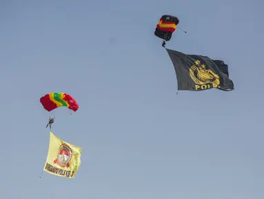 Penerjun payung membawa bendera Polri saat tampil dalam perayaan HUT ke-73 Bhayangkara di Monas, Jakarta, Rabu (10/7/2019). Sebanyak 22 penerjun payung dari TNI dan Polri ikut menyemarakkan HUT ke-73 Bhayangkara. (Liputan6.com/Faizal Fanani)