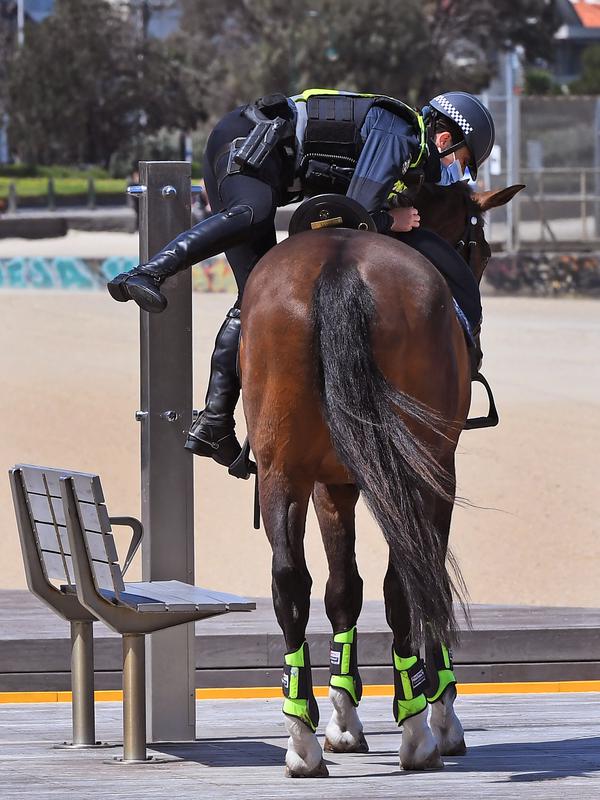 Seorang petugas polisi menunggang kuda selama patroli di sepanjang St Kilda Esplanade di Melbourne Melbourne (26/10/2020). Pejabat kesehatan Australia melaporkan tidak ada kasus virus corona baru atau kematian di negara bagian Victoria. (AFP Photo/William West)