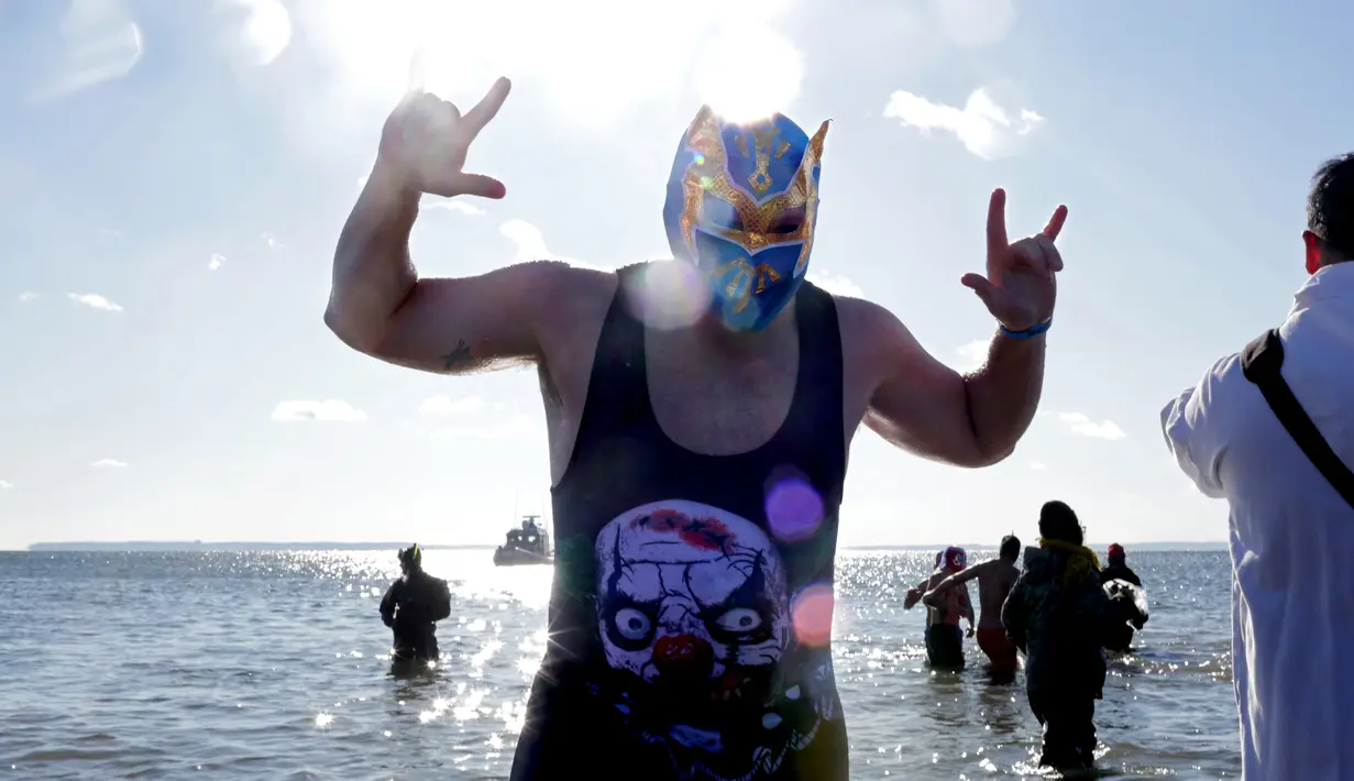 Seorang peserta mengenakan topeng saat mengikuti acara renang Polar Bear Club di Coney Island, New York (1/1). Mereka mengenakan kostum saat berenang di pantai Samudera Atlantik dengan suhu 17 derajat Fahrenheit. (Yana Paskova/Getty Images/AFP)