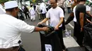 Massa membuang sampah ke kantong plastik yang disediakan oleh relawan di tengah aksi damai 4 November di Jakarta, Jumat (4/11). Mereka mengumpulkan sampah berupa bekas botol minuman dan bungkus nasi yang dibuang anggota ormas (Liputan6.com/Faizal Fanani)