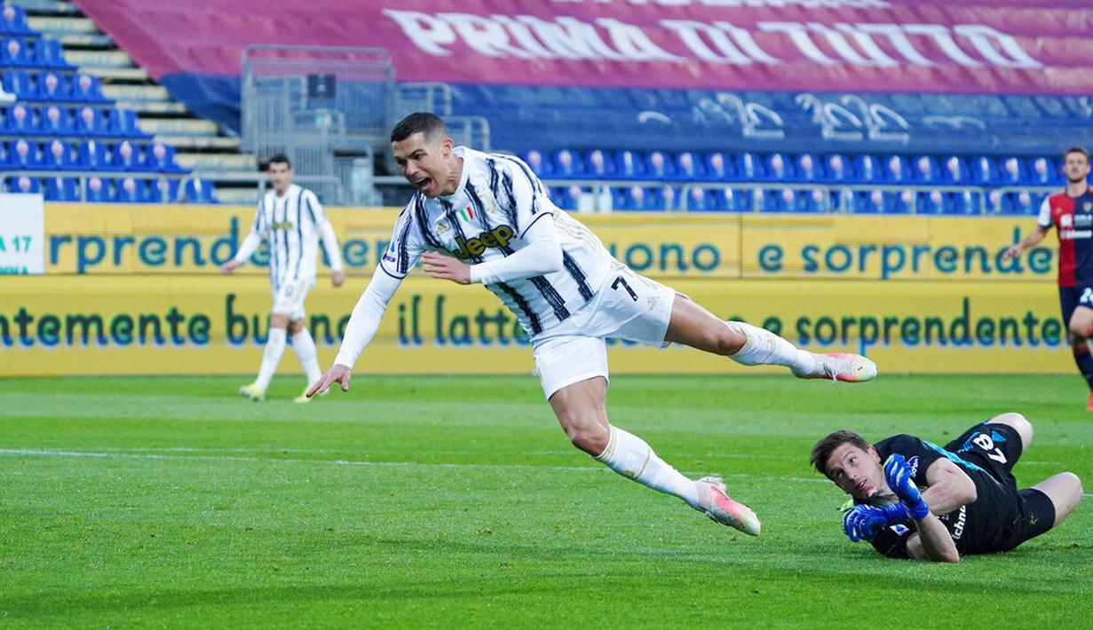 Striker Juventus, Cristiano Ronaldo, terjatuh saat berusaha melewati kiper Cagliari, Alessio Cragno, pada laga Liga Italia di Sardegna Arena, Minggu (14/3/2021). Juventus menang dengan skor 3-1. (Alessandro Tocco/LaPresse via AP)