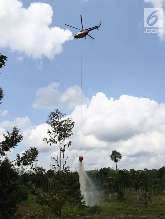 Sebuah helikopter menumpahkan air untuk memadamkan api saat simulasi kebakaran di Tanjungjabung Barat, Jambi, Kamis (3/4). APP Sinarmas alokasikan US 3,8 juta dolar untuk penanggulangan kebakaran selama Asian Games 2018. (Liputan6.com/Angga Yuniar)