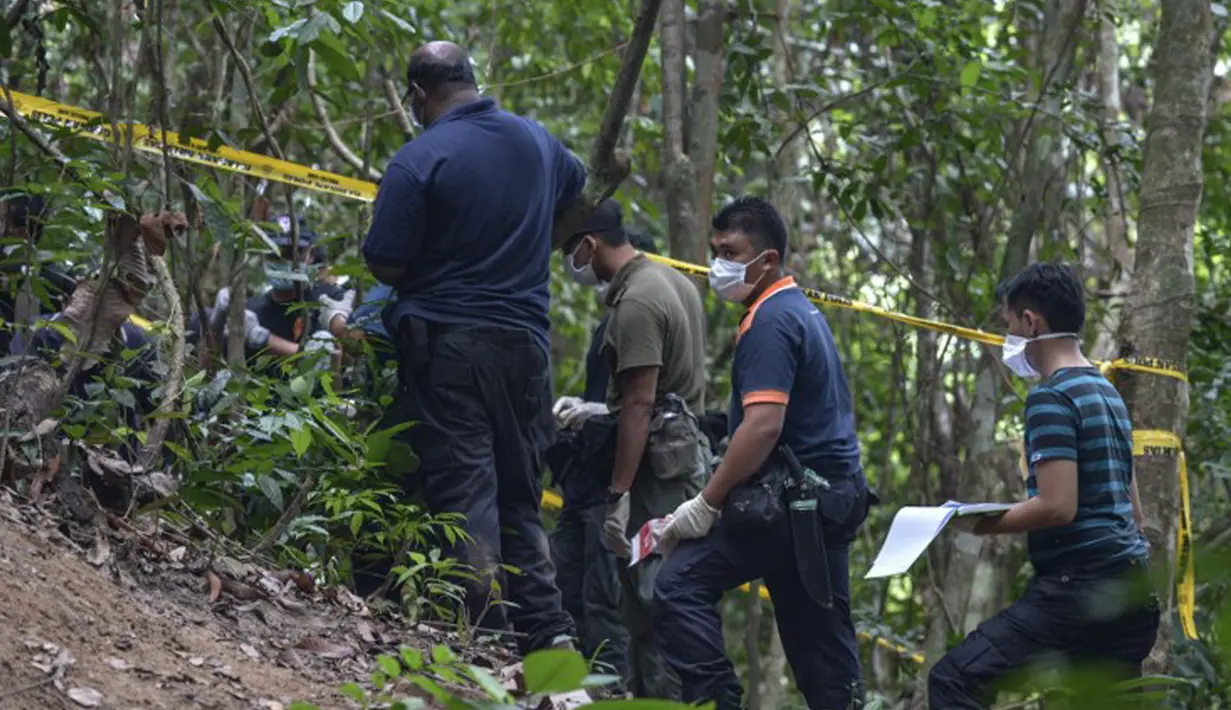Tim forensik Malaysia menggali sebuah makam tak bertanda di Wang Burma, dekat perbatasan Malaysia-Thailand, (26 /5/2015). Penemuan lokasi kuburan massal diduga sebagai migran dari Myanmar dan Bangladesh. (AFP PHOTO/MOHD RASFAN)