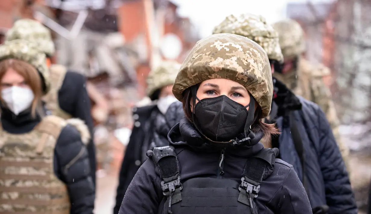 Menteri Luar Negeri Jerman Annalena Baerbock (kanan) terlihat mengenakan helm dan rompi anti peluru saat berkunjung di Shyrokyne, Wilayah Donetsk, Ukraina (8/2/2022). Annalena Baerbock berada di daerah itu selama sekitar 40 menit. (AFP/Pool/Bernd von Jutrczenka)
