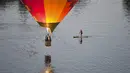 Pedayung saat melihat balon udara yang terbang diatas danau Burley Griffin, Canberra,  Australia, (15/3). Ini dilakukan dilakukan dalam memperingati ulang tahun ke-30 festival Balloon Spectacular Canberra . (REUTERS / Lukas Coch)