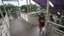 Warga melintasi Jembatan Penyeberangan Orang di kawasan Tanjung Barat, Jakarta, Jumat (11/11).Buruknya desain menyebabkan JPO tersebut tidak tersambung, sehingga warga harus membeli tiket kereta jika ingin menyeberang. (Liputan6.com/Immanuel Antonius)