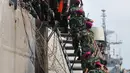 Anggota TNI membantu warga eks Gafatar menuruni tangga kapal saat tiba di Pelabuhan Tanjung Priok, Jakarta, Kamis (28/1/2016). Sebanyak 824 warga eks Gafatar dipulangkan dari Kalimantan untuk dikembalikan ke daerah asal. (Liputan6.com/Gempur M Surya)
