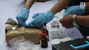 Petugas mengidentifikasi barang bukti narkoba berupa ganja dan sabu di Polres Jakarta Utara, Senin (19/2). Sabu tersebut dimusnahkan dengan diblender, sedangkan ganja dibakar dengan cara dicampur minyak tanah. (Liputan6.com/Arya Manggala)