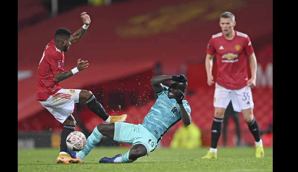 Pemain Manchester United, Fred (kiri) berebut bola dengan pemain Liverpool, Sadio Mane pada laga babak keempat FA Cup 2020-21 di Old Trafford, Senin (25/01/2021). (Foto: AP/Pool/Laurence Griffiths)