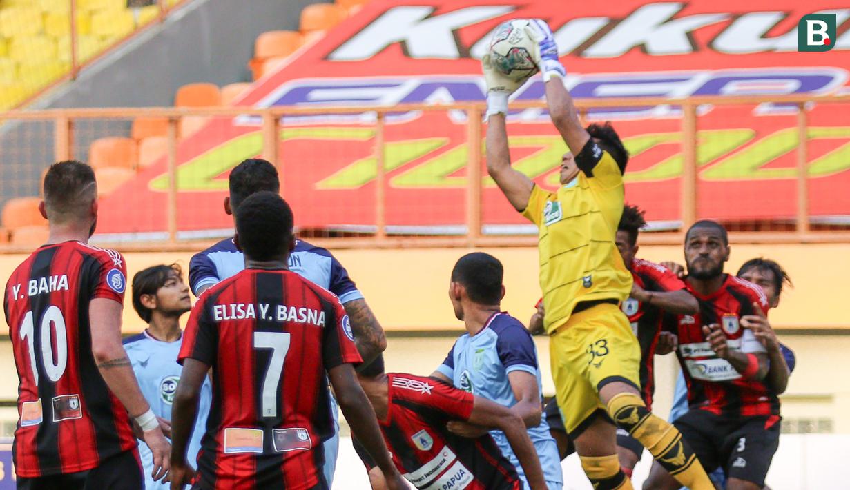 Kiper Persela Lamongan, Dwi Kuswanto (atas) berusaha menyelamatkan bola saat melawan Persipura Jayapura dalam laga pekan kedua BRI Liga 1 2021/2022 di Stadion Wibawa Mukti, Cikarang, Jumat (10/09/2021). (Foto: Bola.com/Bagaskara Lazuardi)