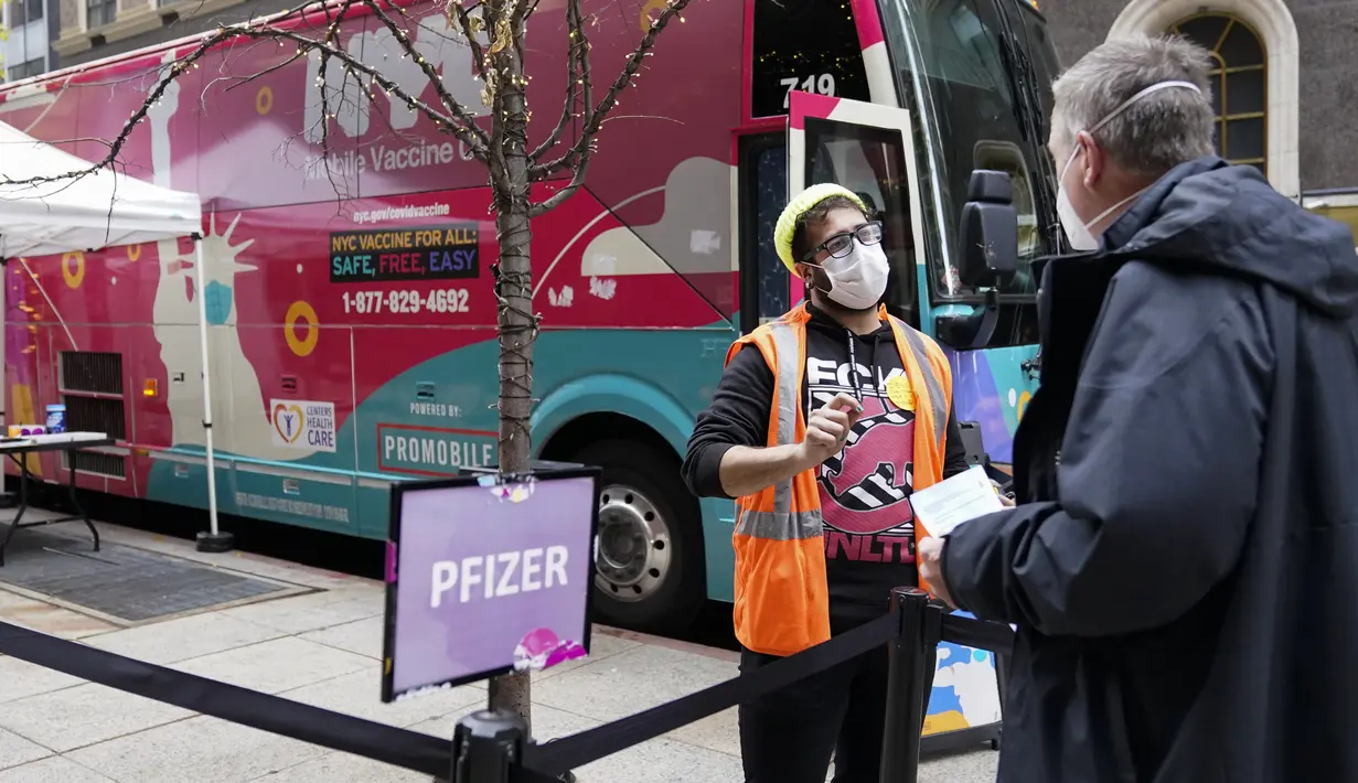 Pekerja kesehatan memeriksa seorang pria di klinik vaksin keliling NYC di Midtown Manhattan, Senin (6/12/2021). Wali Kota Bill de Blasio mengumumkan semua pengusaha swasta Kota New York harus mewajibkan pekerja mereka untuk divaksinasi COVID-19 mulai 27 Desember. (AP Photo/Mary Altaffer)